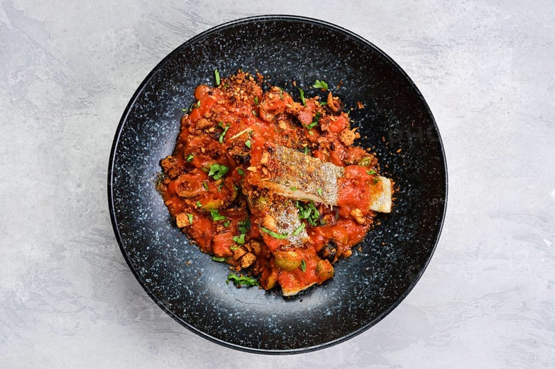Top view of roasted zander served with steamed tomato