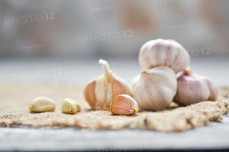 Garlic cloves and bulbs on wooden cutting board