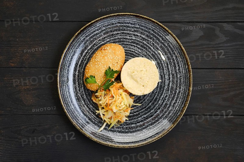 Top view of chicken cutlet stuffed with cheese served with millet porridge and pickled cabbage