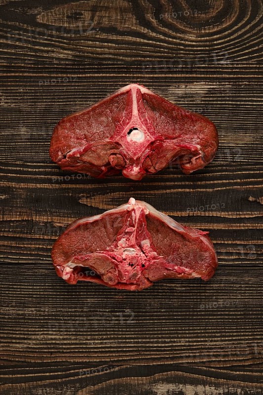 Overhead view of raw fresh deer backstrap over dark wooden background