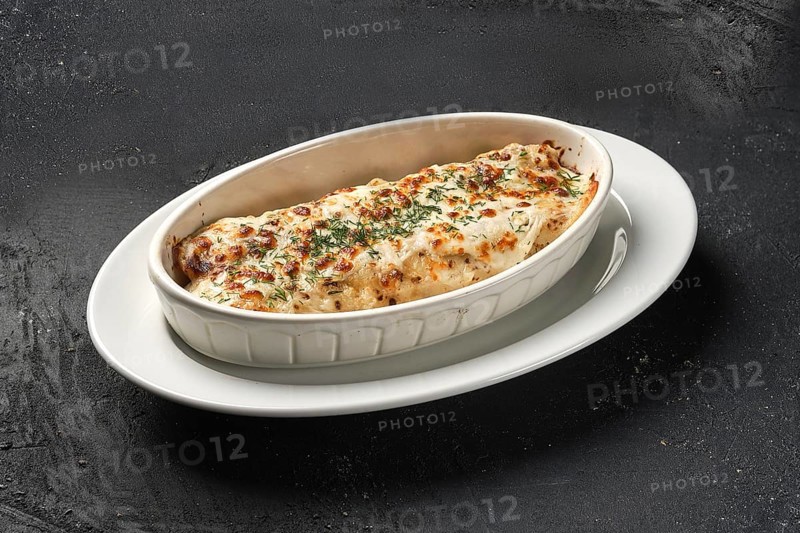 Pancakes with meat and cheese baked in oven on dark background