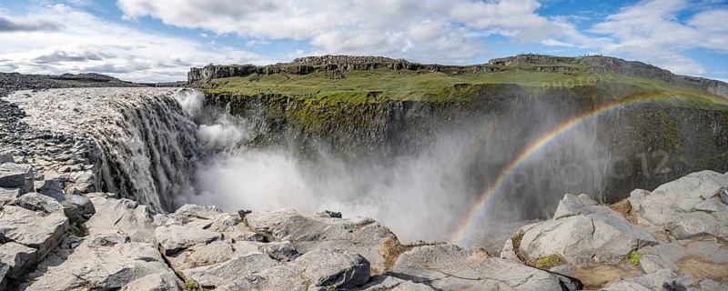 Canyon with falling water masses and rainbow