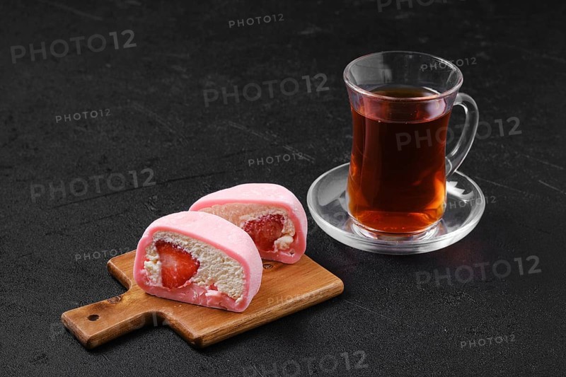Sweet dessert mochi with strawberry cut on half with fruit tea