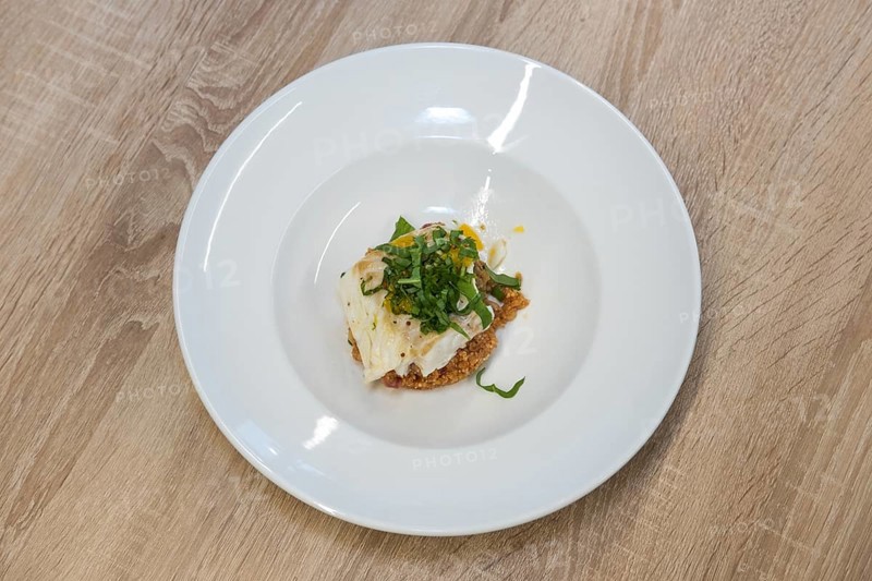 Top view of fried white fish fillet with quinoa porridge on wooden table