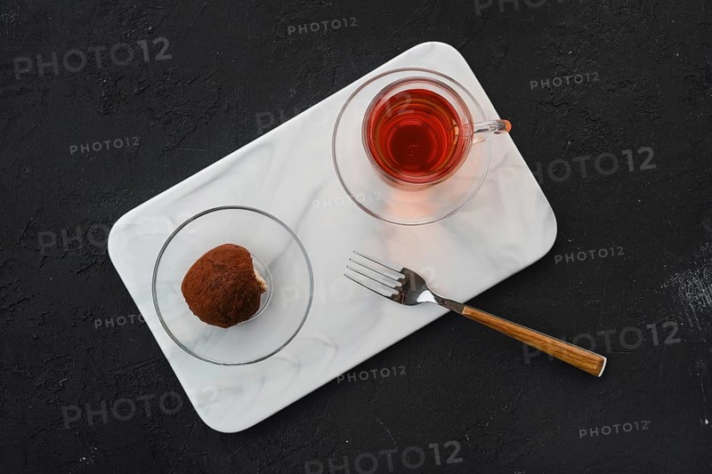 Top view of chocolate biscuit dough cake and a cup of tea on a table