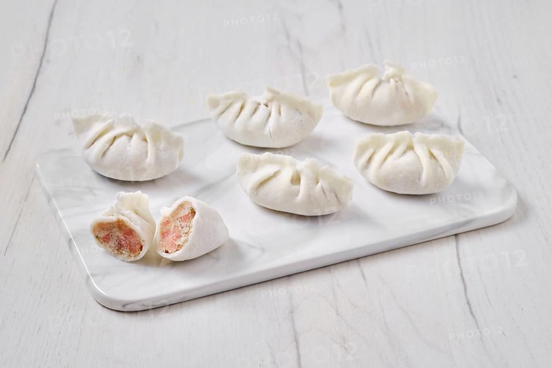 Frozen dumplings stuffed with liver and provencal herbs on marble serving plate