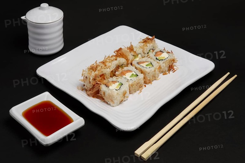 Portion of bonito rolls served on plate with soy sauce and wooden hashi