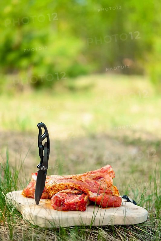 Fresh pork ribs with salt and pepper on cutting board outdoor. Selective focus photo