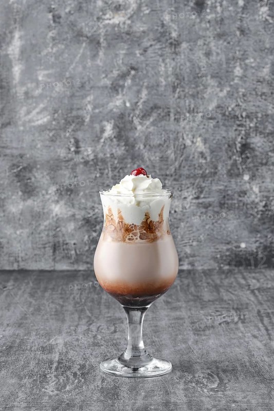 Coffee cocktail with whipped cream on shabby grey background