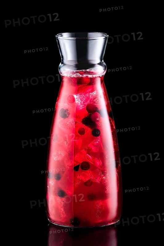 Cold sangria with forrest berries in a jar isolated on black background