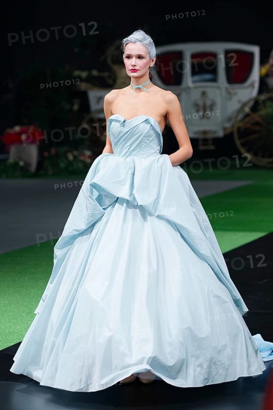 Fashion model in long designers dress walking on runway