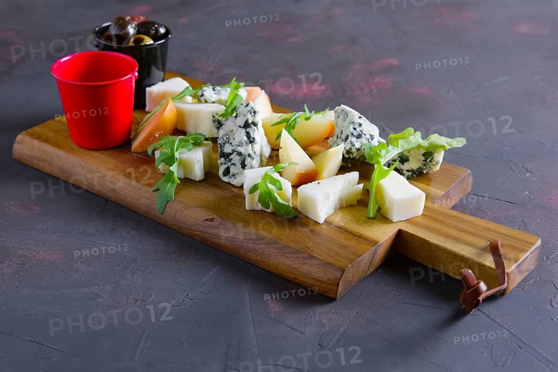 Cheese plate with honey and black and yellow olives