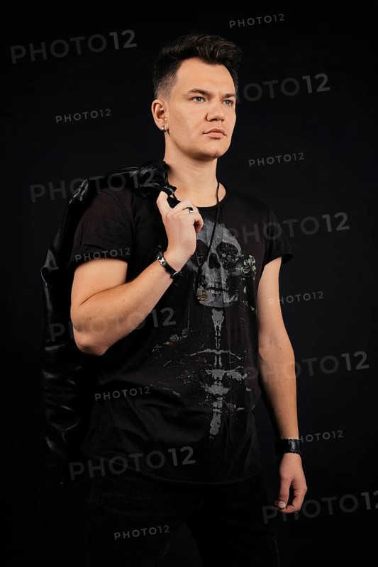 Strong and confident man holding leather jacket over his shoulder