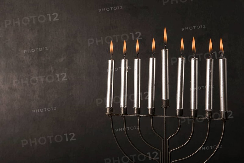 Menorah with candles near gray wall