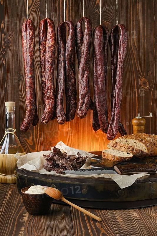 Assortment of dried venison sausages on the rope and jerky venison
