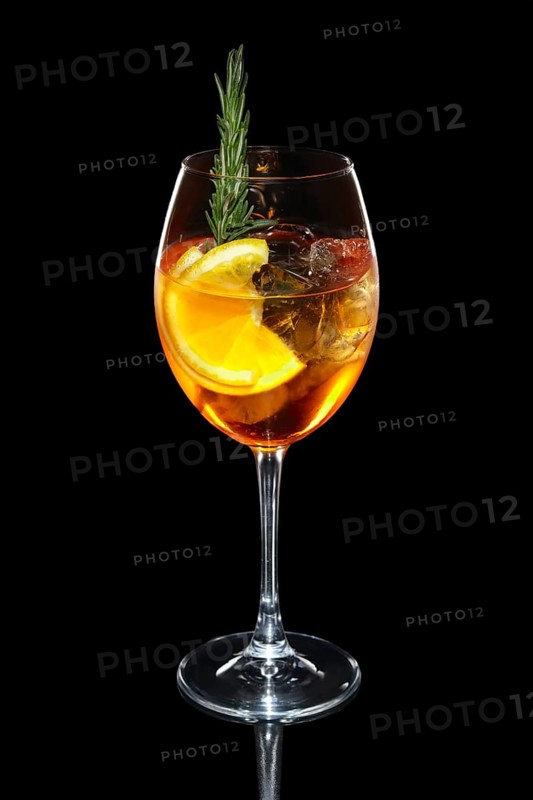 Cold Apple and orange cocktail with a sparkling wine with ice in wine glass isolated on black
