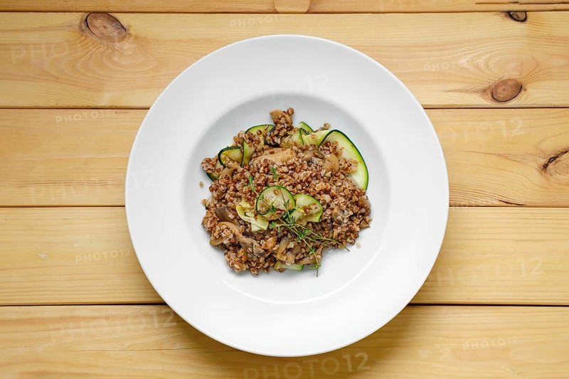 Overhead view of boiled buckwheat with marinated mushrooms and fresh cucumber