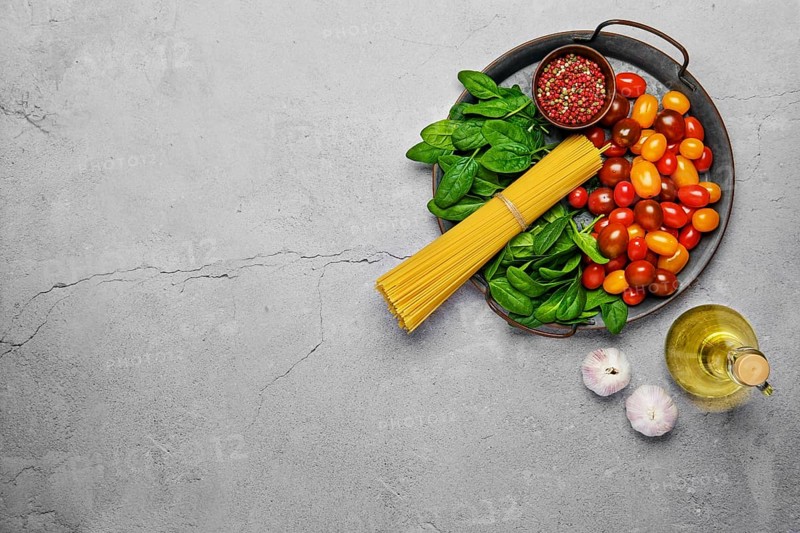 Overhead view of a bunch of raw spaghetti with spinach