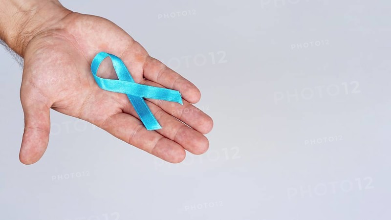 Close up hand holding blue ribbon