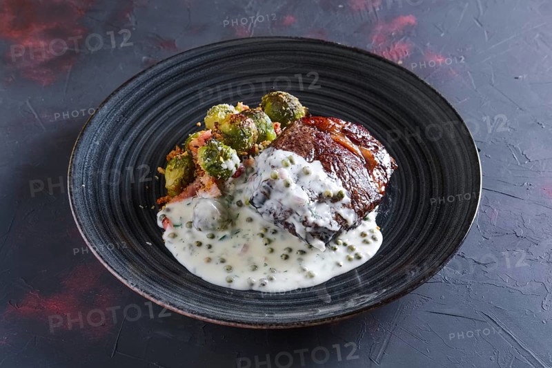 Fried beefsteak with Brussels sprouts and creamy pea sauce