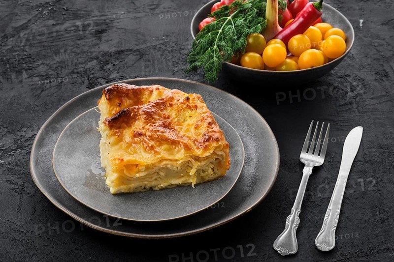 Cheese puff pie from unleavened dough on black wooden background