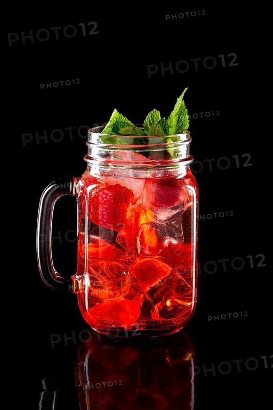 Cold fruit lemonade in mason jar isolated on black background