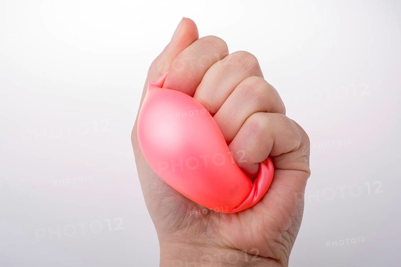 Squeezing pink balloon with hand on a white background