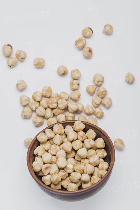 Hazelnuts spilled near bowl