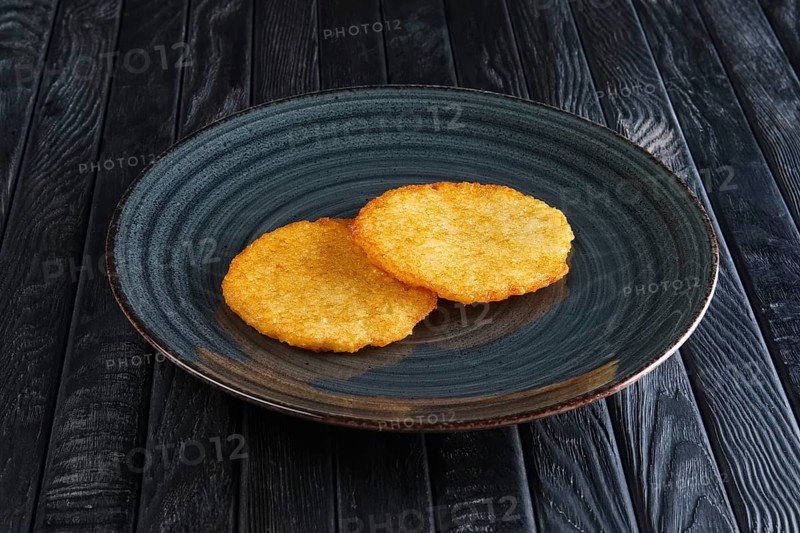 Portion of fried potato pancakes on dark wooden table