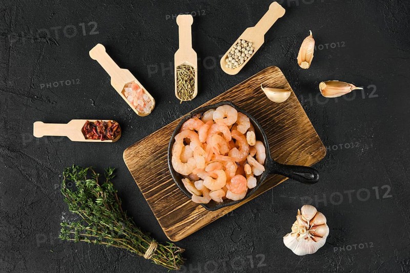 Overhead view of frozen peeled shrimps in frying pan