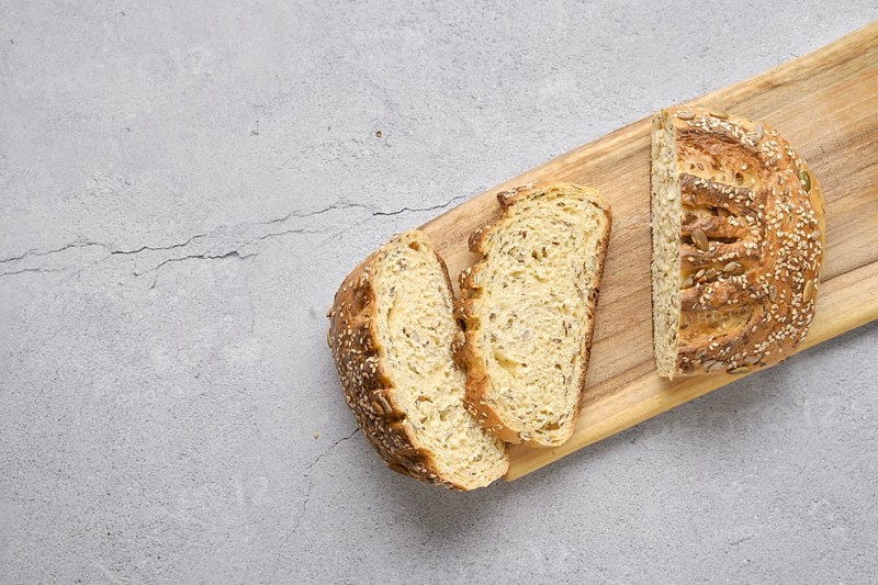 Fresh oats bread with sunflower seeds and sesame on wooden table