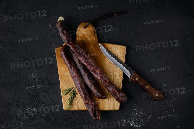 Top view of dry cured beef sausage on cutting board