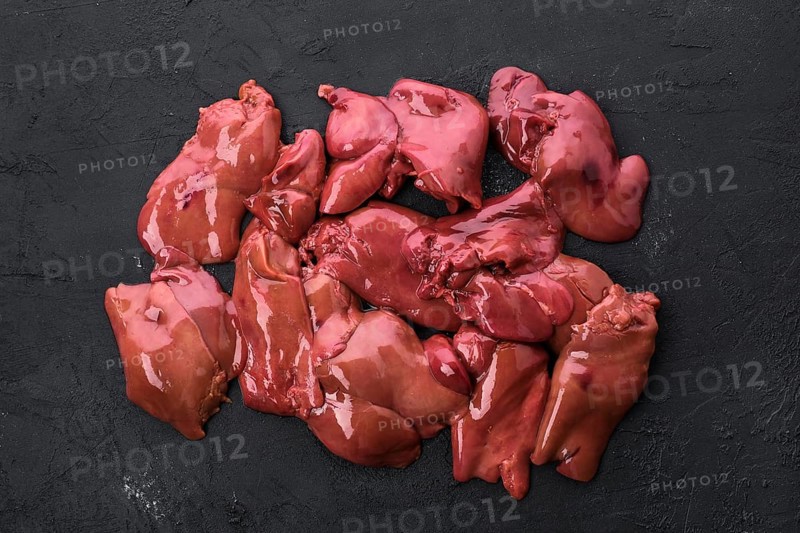 Top view of raw duck liver on black concrete background