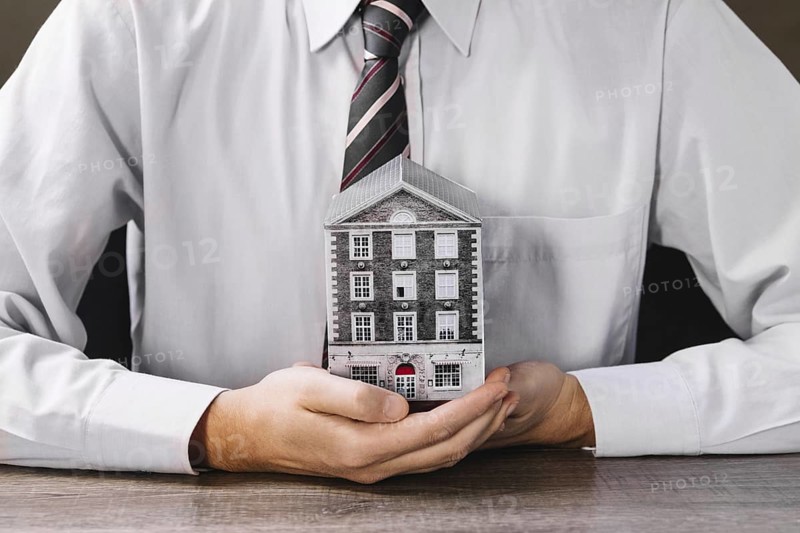 Man holding miniature house hands