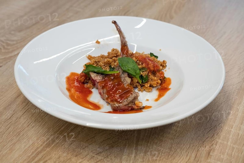 Fried lamb rib with quinoa porridge on wooden table