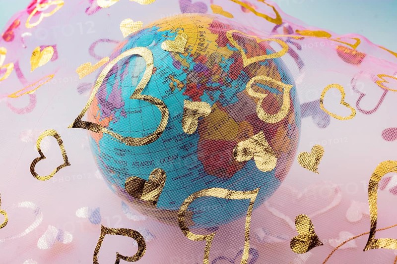 Little model globe under a fabric with heart patterns
