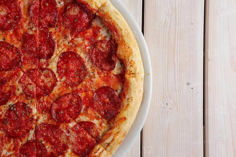 Classic pizza pepperoni on wooden background