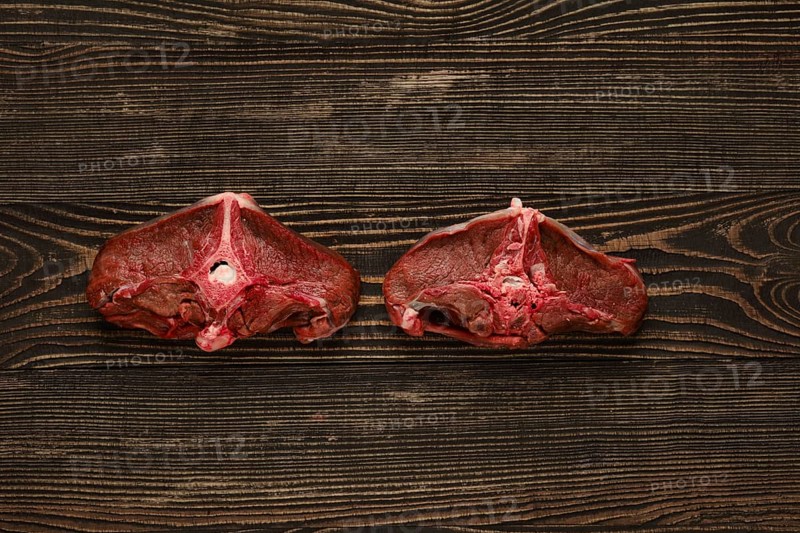 Overhead view of raw fresh deer backstrap over dark wooden background