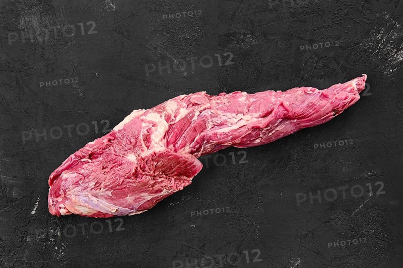 Raw fresh beef whole tenderloin on black background