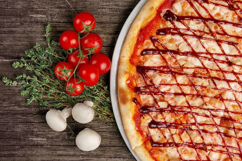 Pizza with barbecue sauce and ingredints on wooden table