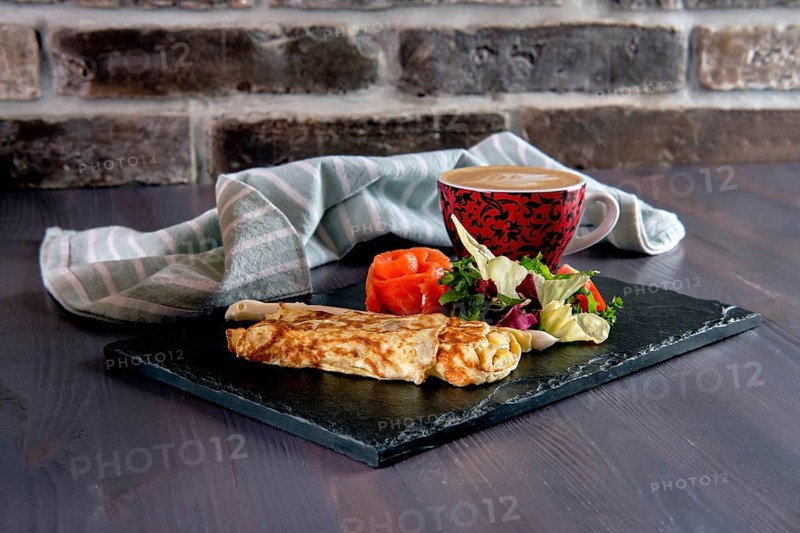 Omelette with salmon on slate plate and cup of latte
