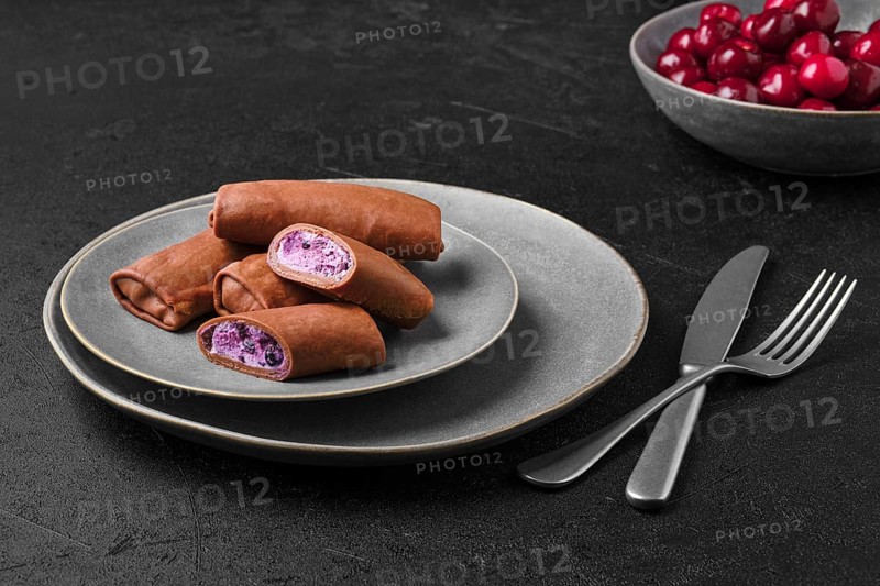 Thin chocolate pancakes stuffed with curd