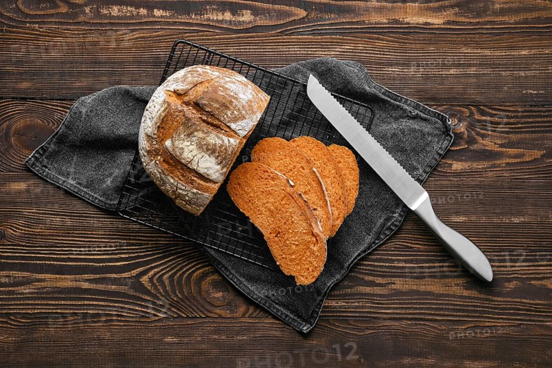 Overhead view of artisan whole grain tomato wheat bread cut on slices on wooden table