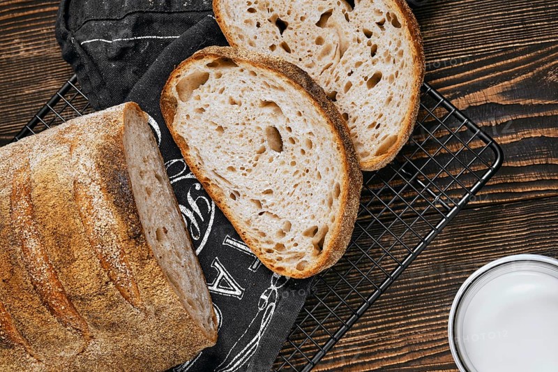 Closeup view of loaf of artisan sourdough bread with porous texture on wooden table