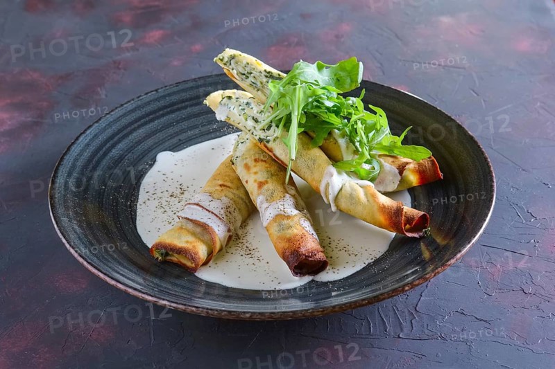 Thin pancakes stuffed with arugula and cheese