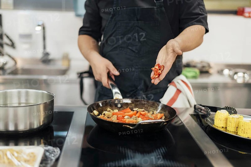 Male chef adding chili dish