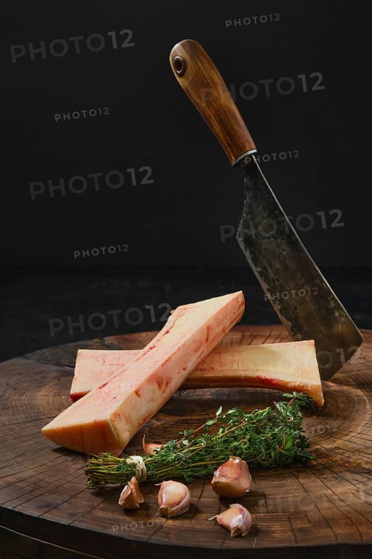 Raw beef bone marrow chopped on half on wooden stub
