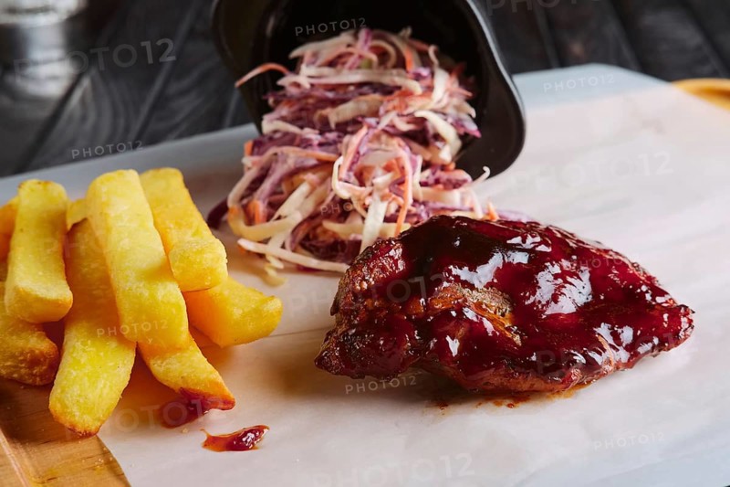 Rustic lunch. Grilled ribs with fried potato and red cabbage salad