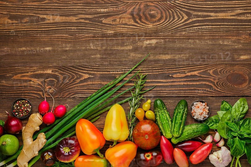 Top view of wooden background with different types of vegetables