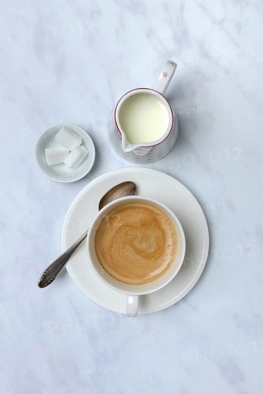 Cup with coffee and pot of milk